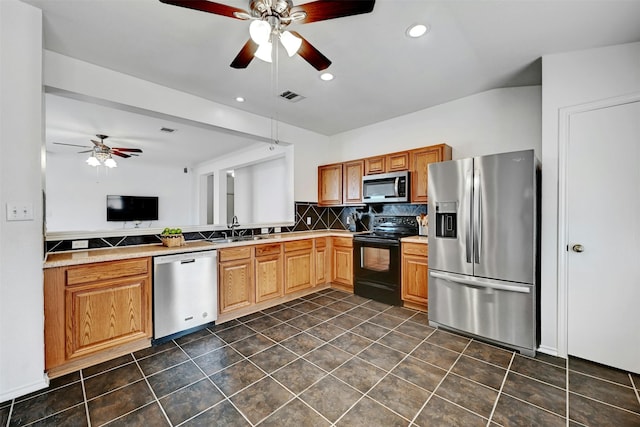 kitchen with sink, appliances with stainless steel finishes, decorative backsplash, vaulted ceiling, and kitchen peninsula