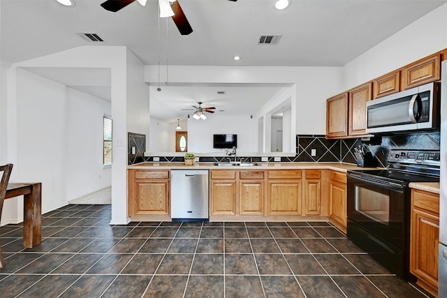 kitchen featuring lofted ceiling, sink, tasteful backsplash, kitchen peninsula, and stainless steel appliances