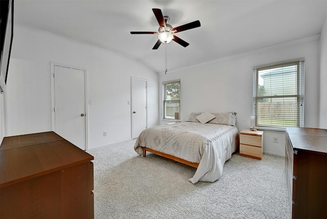 bedroom featuring ceiling fan, light colored carpet, lofted ceiling, and crown molding