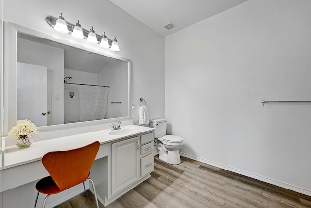 bathroom featuring vanity, hardwood / wood-style floors, toilet, and walk in shower