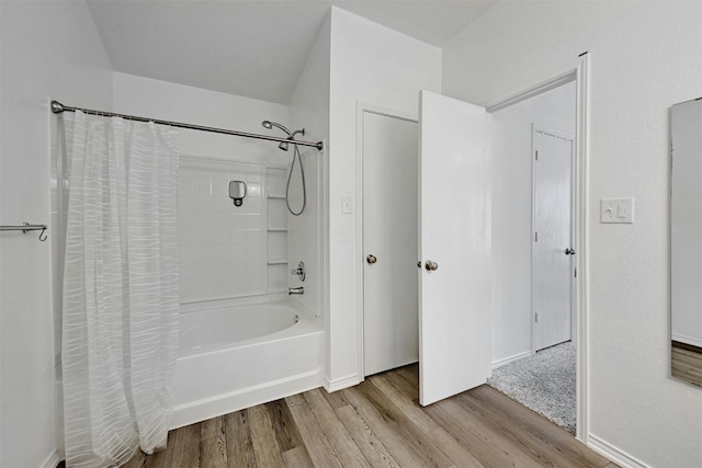 bathroom with hardwood / wood-style flooring and shower / bath combo