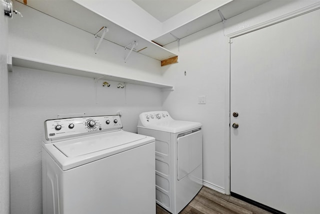 laundry area with dark hardwood / wood-style floors and washing machine and dryer