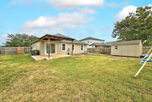 rear view of property with a lawn, a deck, and a storage unit