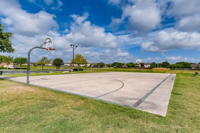 view of basketball court with a yard