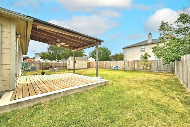 view of yard with a wooden deck, central AC, ceiling fan, and a storage shed