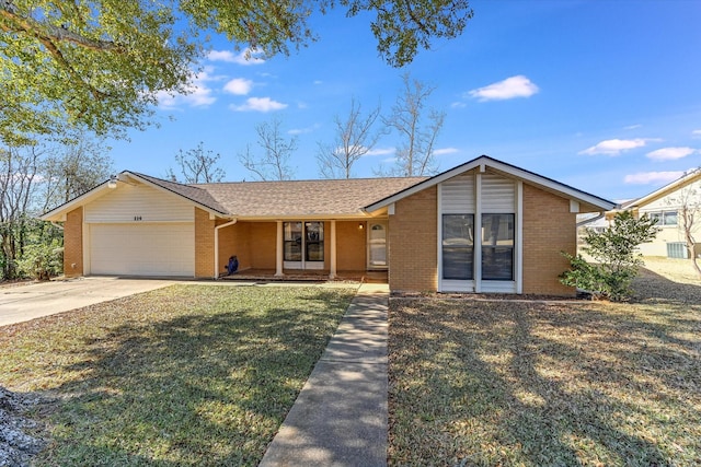 ranch-style house with a garage, covered porch, and a front yard