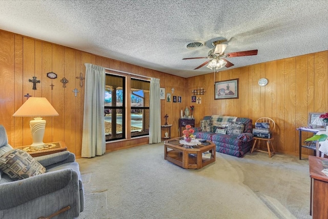 living room featuring carpet, a textured ceiling, and wood walls