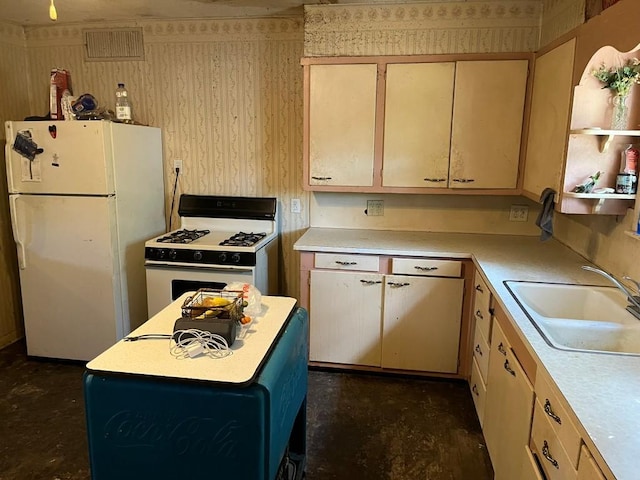 kitchen with white appliances, light brown cabinetry, and sink