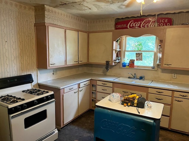 kitchen featuring a kitchen island, white gas range, and sink