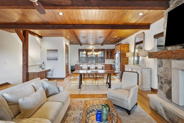 living room featuring wood ceiling, a fireplace, light hardwood / wood-style floors, and beamed ceiling