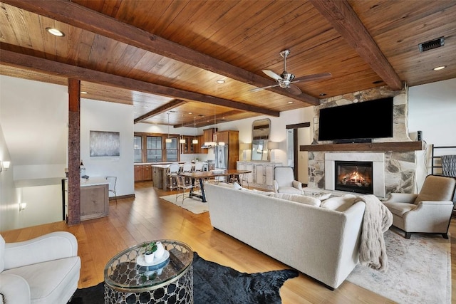 living room with ceiling fan, wood ceiling, light hardwood / wood-style flooring, and beamed ceiling