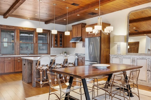 dining area with beamed ceiling, light wood-type flooring, an inviting chandelier, and wood ceiling