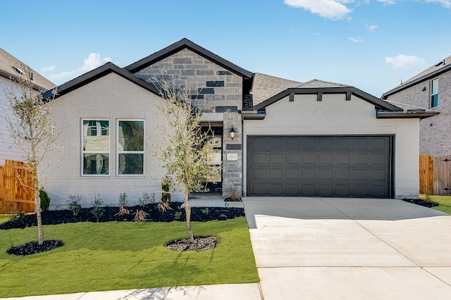 french country home featuring driveway, fence, a front yard, a garage, and brick siding