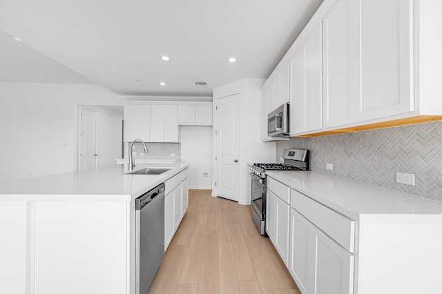 kitchen with visible vents, light wood-style flooring, a sink, white cabinetry, and appliances with stainless steel finishes