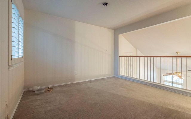 carpeted spare room featuring lofted ceiling