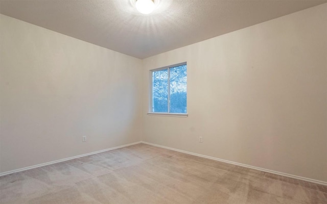 unfurnished room featuring light colored carpet