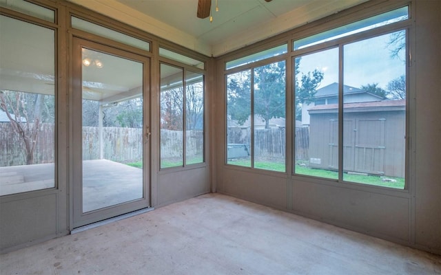 unfurnished sunroom featuring ceiling fan and a healthy amount of sunlight