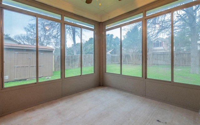 unfurnished sunroom featuring ceiling fan and a healthy amount of sunlight