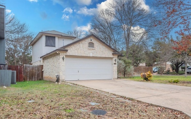 view of side of property featuring a garage, a yard, and central air condition unit