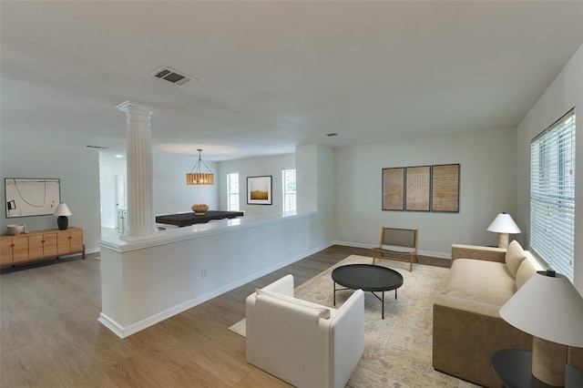 living room featuring light hardwood / wood-style flooring and decorative columns