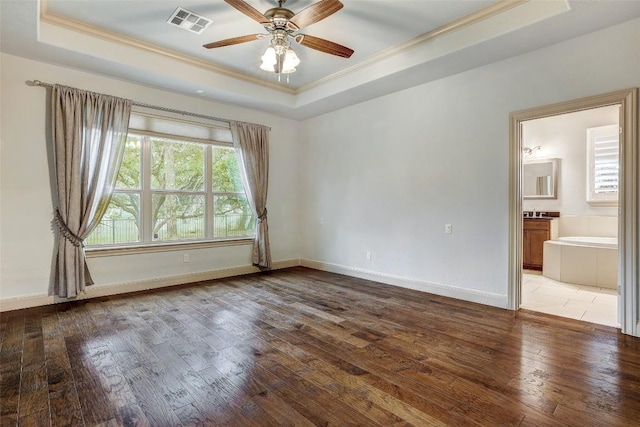 spare room featuring a tray ceiling, light hardwood / wood-style flooring, and ornamental molding