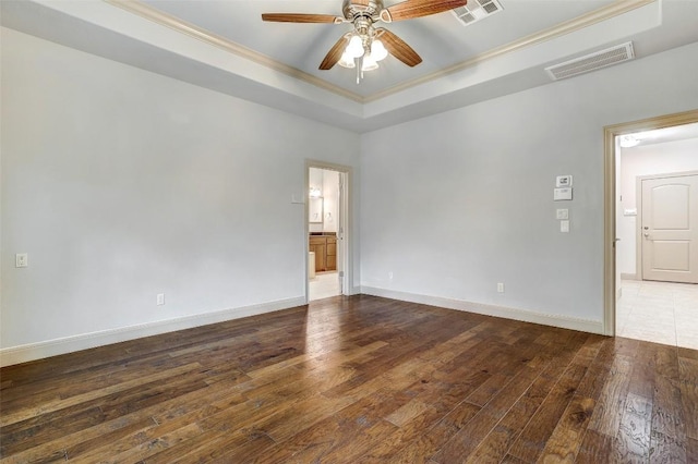 unfurnished room featuring a raised ceiling, crown molding, dark wood-type flooring, and ceiling fan