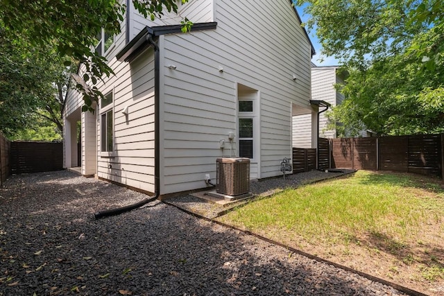 view of home's exterior with a lawn and central air condition unit