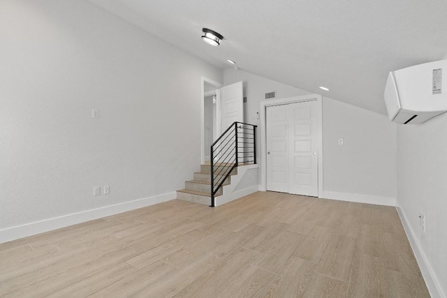 interior space with lofted ceiling and light hardwood / wood-style flooring