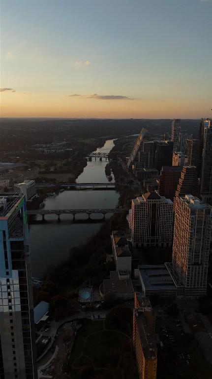 aerial view at dusk featuring a water view