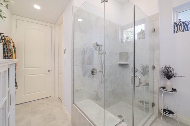 bathroom with a shower with door and tile patterned floors