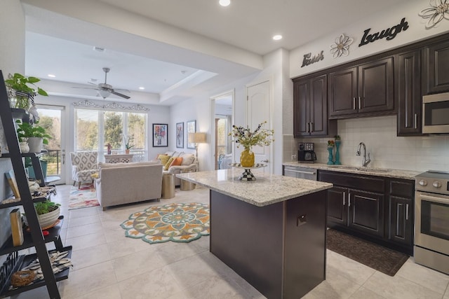 104 Bella Toscana Ave Unit 2211, Lakeway, TX 78734 - kitchen with appliances with stainless steel finishes, a kitchen island, open floor plan, decorative backsplash, and light stone countertops