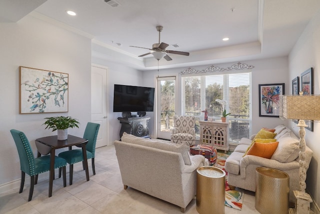 living room featuring crown molding, a tray ceiling, ceiling fan, and light tile patterned flooring