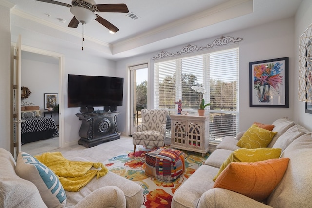 tiled living room with ornamental molding, a raised ceiling, and ceiling fan