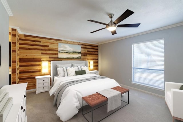 carpeted bedroom with ceiling fan, baseboards, wood walls, and crown molding