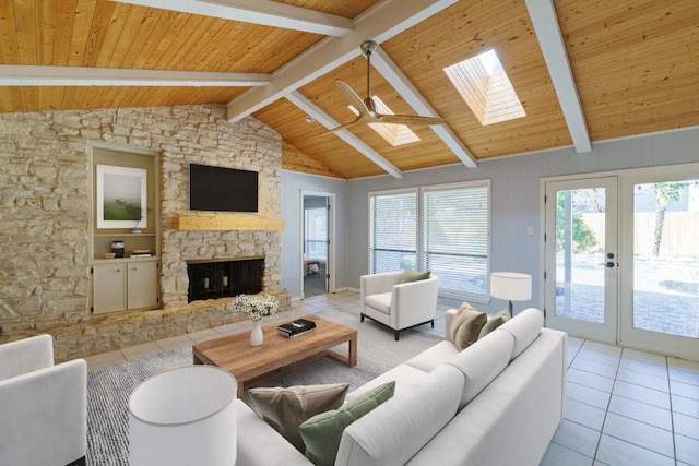 tiled living area featuring lofted ceiling with skylight, french doors, a fireplace, and wooden ceiling