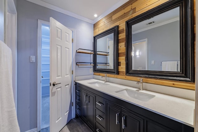 bathroom featuring double vanity, visible vents, crown molding, and a sink