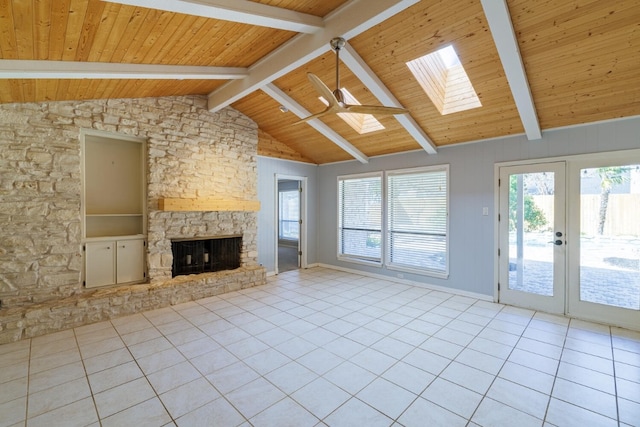 unfurnished living room featuring french doors, vaulted ceiling with skylight, a fireplace, light tile patterned floors, and wood ceiling