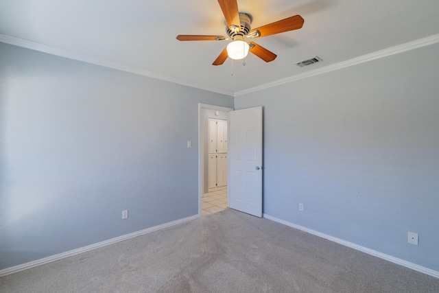 spare room featuring visible vents, crown molding, baseboards, light carpet, and a ceiling fan