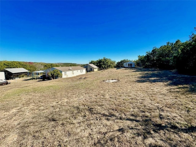 view of yard featuring a rural view and a storage unit