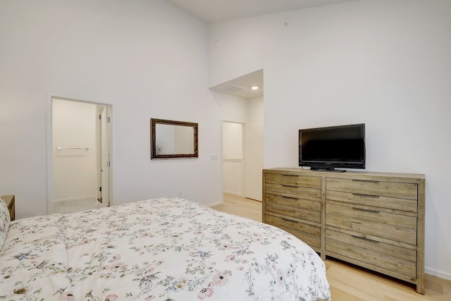 bedroom with ensuite bathroom and light wood-type flooring