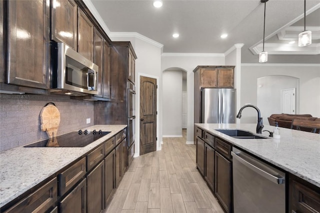 5204 La Terraza Ln, Killeen, TX 76549 - kitchen featuring stainless steel appliances, arched walkways, crown molding, light stone countertops, and backsplash