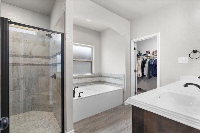 5204 La Terraza Ln, Killeen, TX 76549 - full bath with a bath, a shower stall, a spacious closet, wood finished floors, and double vanity