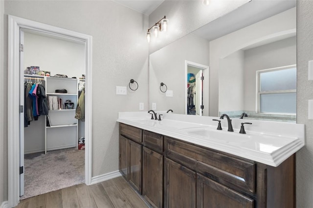 5204 La Terraza Ln, Killeen, TX 76549 - bathroom featuring double vanity, wood finished floors, and a walk in closet
