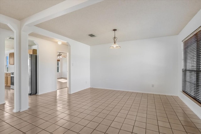 empty room with ceiling fan and light tile patterned flooring