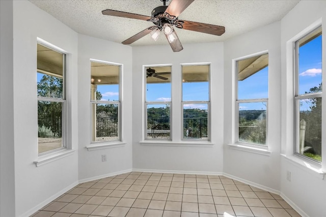 unfurnished sunroom featuring ceiling fan