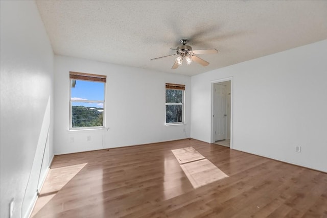 spare room with hardwood / wood-style flooring, ceiling fan, and a textured ceiling