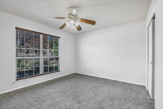 carpeted spare room with ceiling fan and a textured ceiling