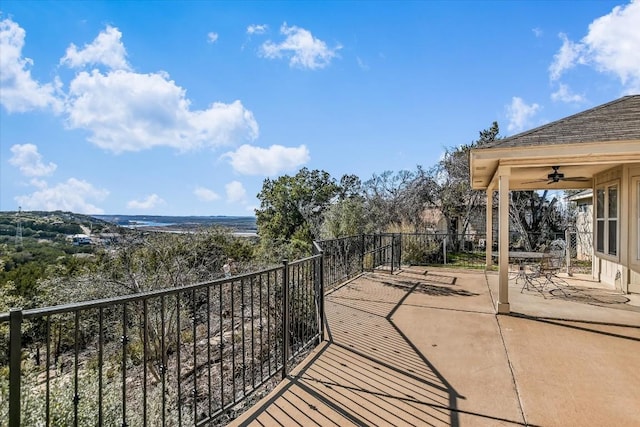 view of patio featuring a water view and ceiling fan