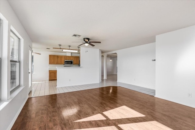 unfurnished living room with light hardwood / wood-style floors and ceiling fan