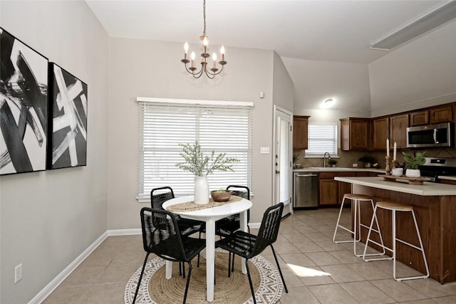 dining room with light tile patterned flooring, lofted ceiling, and a healthy amount of sunlight